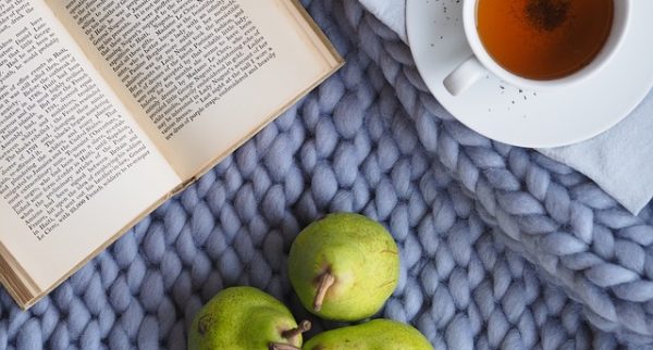 A book, cup of team and pears