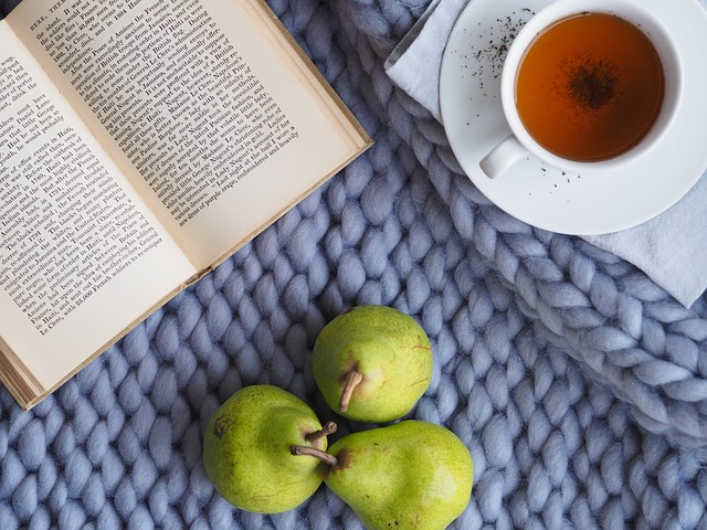 A book, cup of team and pears