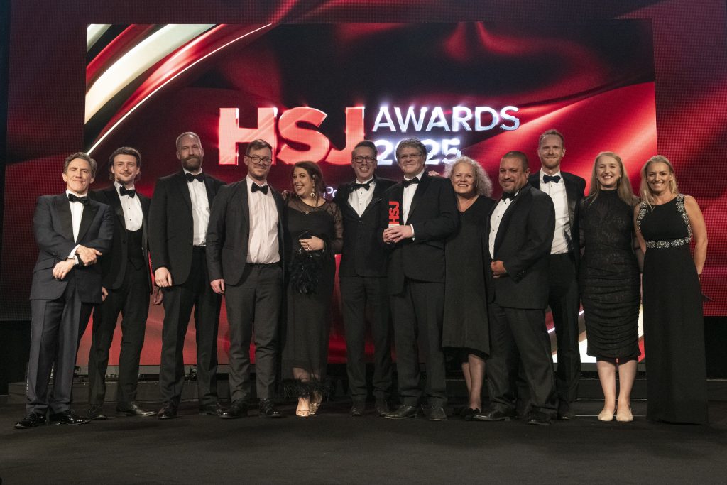 Picture of 11 people, mixture of men and women, who attended the award ceremony with the award and host Rob Brydon.